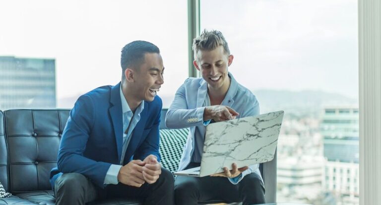 two men in suit sitting on sofa